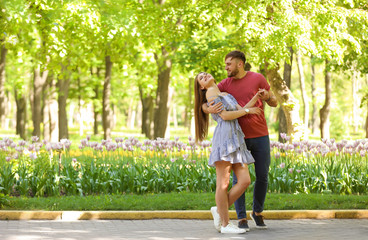 Obraz premium Happy young couple in green park on sunny spring day