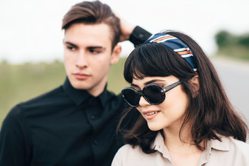 Cute young guy standing next to a beautiful girl on a green background behind a city