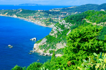 Beautiful summer seascape. Awesome view picturesque green hills coastline sea bay with crystal clear azure water, distant islands in the calm warm sea. Agios Stefanos cape. Afionas. Corfu. Greece.