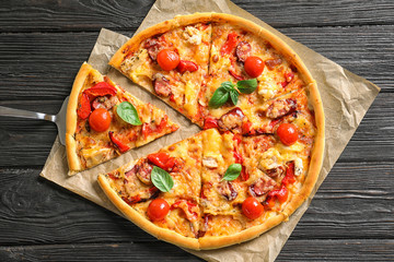 Delicious pizza with tomatoes and sausages on wooden table, top view