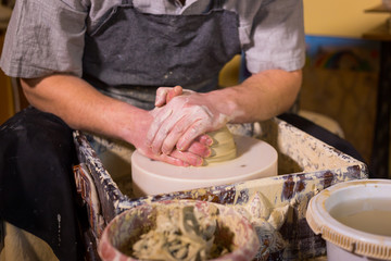 Professional male potter working with clay on potter's wheel