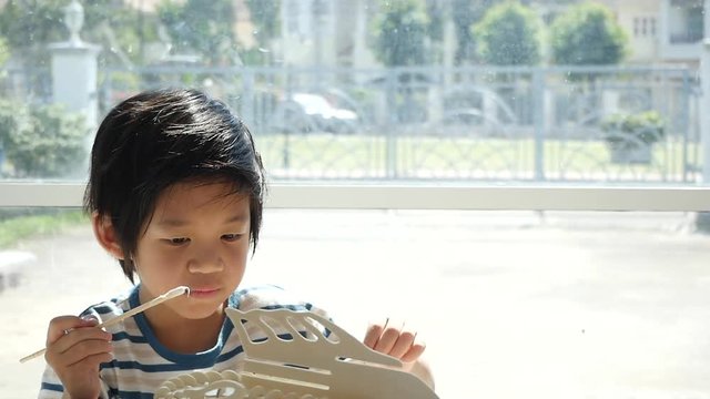 Cute Asian child  builds a toy of wood slow motion 