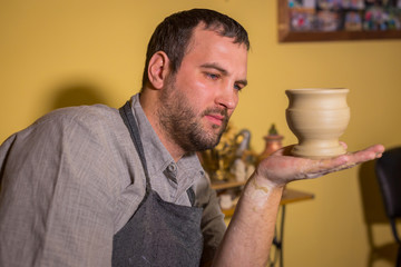 Potter examining earthenware mug