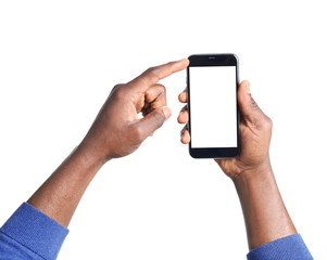 African-American man holding mobile phone with blank screen in hands on white background