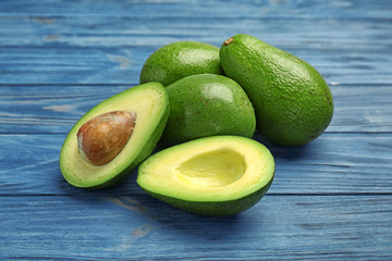 Tasty ripe green avocados on wooden background