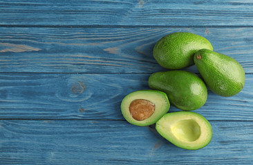 Tasty ripe green avocados on wooden background, top view