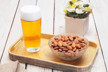 Almonds  with beer on wooden table       