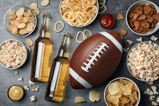 Table Full Of Tasty Snacks And Beer Prepared For Watching American Football On TV, Top View