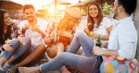Group of young friends laughing and drinking beer