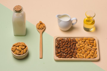 Fototapeta na wymiar Almond oil in bottle and milk with almonds on black wooden table