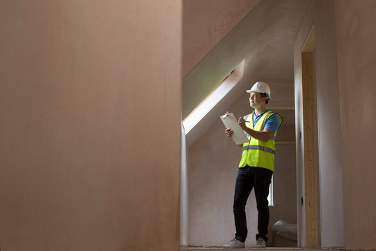 Inspector On Building Site With Clipboard
