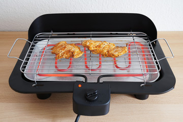 grilling marinated grilled chicken on electric table grill