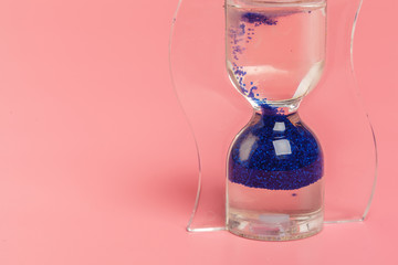 Close up of hourglass against pink background