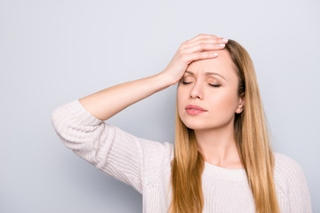 Portrait of overworked disappointed woman feeling bad holding hand on forehead with close eyes suffering from spasm, syndrome, isolated on grey background