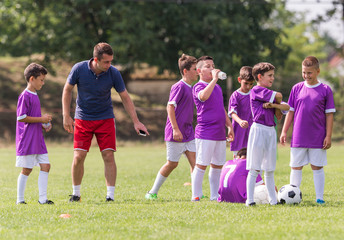 Naklejka premium Coach is giving advice to soccer players at football match