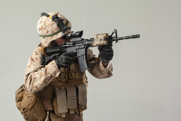 Soldier in camouflage holding rifle