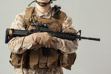 Soldier in camouflage holding rifle