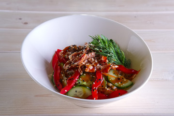 Salad with meat, bell pepper, tomato, cucumber and sesame
