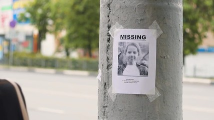 leaflet about the missing child hanging on a pole,slow mo