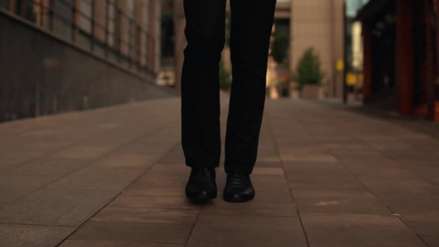 young handsome businessman walking in the evening. trendy man wearing elegant suit walks outdoor. on background beautiful urban cityscape