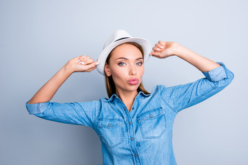 Portrait of lovely sweet girl with pout lips holding hat with two hands posing sending kiss at camera isolated on grey background