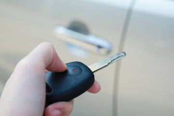 Woman presses remote control car key. Door lock system.