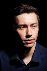 Portrait of young man in his 20s on black background in studio photo