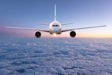 Naklejka premium Samolot komercyjny lecący nad chmurami.