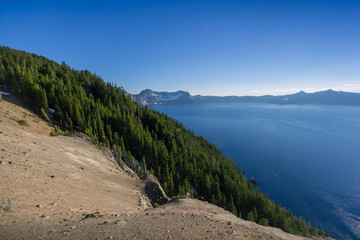 Beautiful scenery of the volcanic cliff with pine trees as seen from the west rim in Crater Lake, Oregon, USA