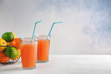 Glasses with fresh citrus juice on table