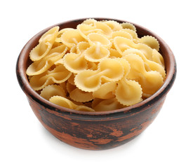 Bowl with raw pasta on white background