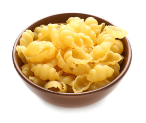 Bowl with raw pasta on white background