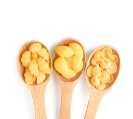 Wooden spoons with different types of pasta on white background