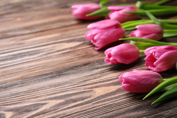 Beautiful fresh tulips on wooden background