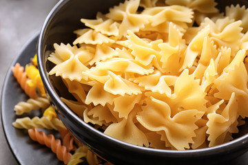 Dishware with uncooked pasta on table, closeup