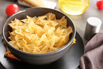 Dishware with uncooked pasta on table, closeup