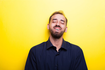 Fototapeta premium Happy joyful man smiling on yellow background in studio photo 