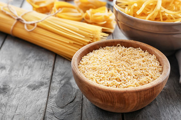 Bowl with uncooked pasta on table