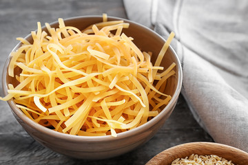 Bowl with uncooked pasta on table