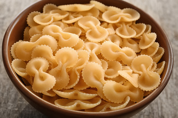 Bowl with uncooked pasta on table, closeup