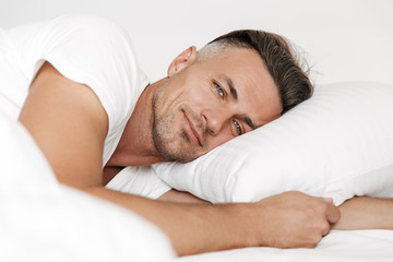 Fototapeta na wymiar Smiling man lying in bed