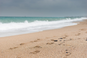 Fototapeta na wymiar Foot prints on a sandy beach on a stormy day