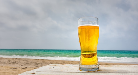 Glass of pale golden Pilsener beer at the seaside