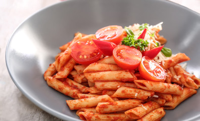 Tasty pasta with tomato sauce and cheese on plate, closeup