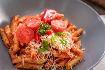 Tasty pasta with tomato sauce and cheese on plate, closeup