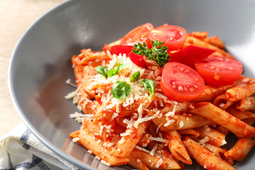 Tasty pasta with tomato sauce and cheese on plate, closeup