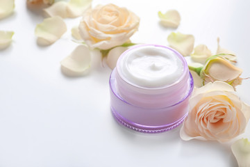 Obraz na płótnie Canvas Jar with cream and flowers on white background. Skin care cosmetics