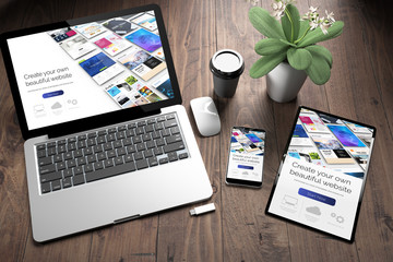 three devices on wooden desk top view website builder