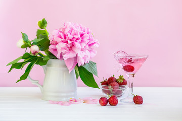 Pink peony next to glass of pink wine.