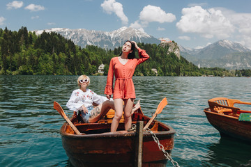 beautiful young women in boat at tranquil mountain lake, bled, slovenia